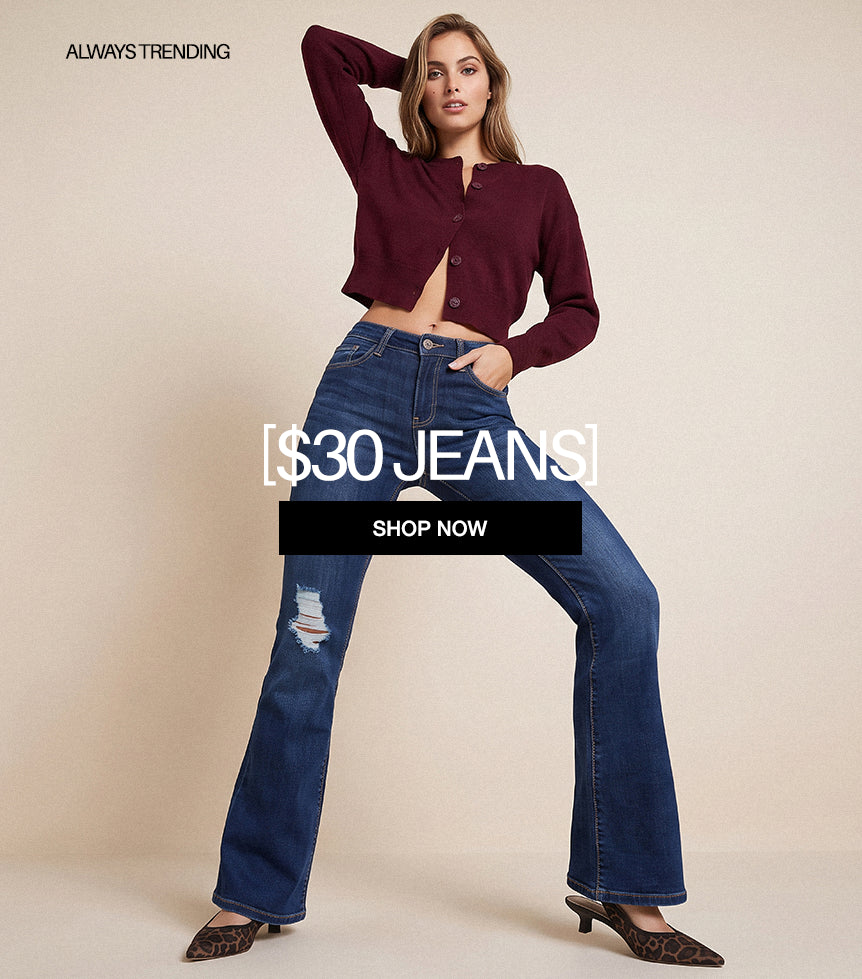 A model posing in a studio setting wearing a maroon cropped long-sleeve top and blue high-waisted flare jeans with a distressed knee detail. The image features promotional text overlays reading '$30 JEANS' and 'SHOP NOW' with 'ALWAYS TRENDING' in the top left corner.