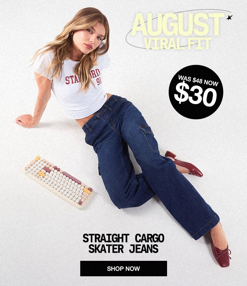 A woman reclines on a light gray studio background wearing dark blue straight cargo skater jeans and a white graphic T-shirt. Text overlays read 'AUGUST VIRAL FIT,' 'STRAIGHT CARGO SKATER JEANS,' and 'SHOP NOW,' with a black price callout showing '$30' and '$48 NOW.